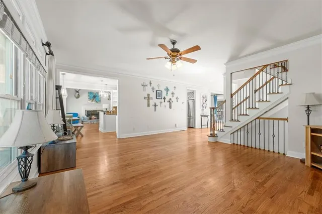 a view of an empty room with wooden floor and a chandelier