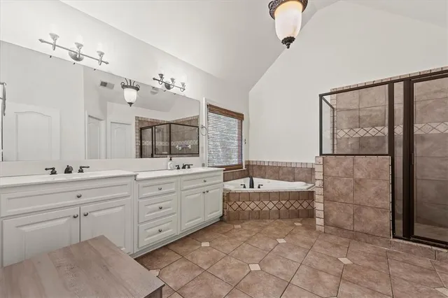 a spacious bathroom with a granite countertop sink a mirror and a bathtub