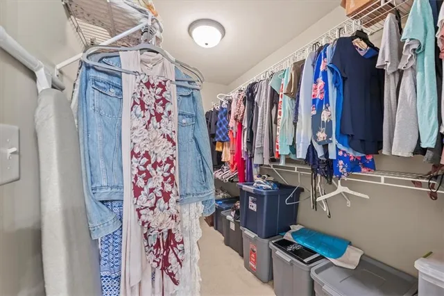 a view of walk in closet with clothes