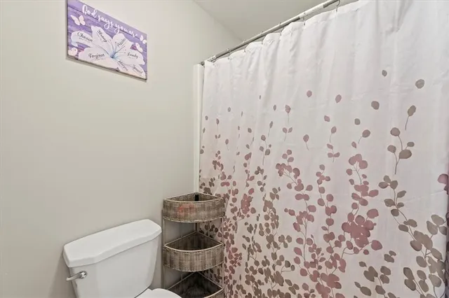 a white toilet sitting next to a shower curtain