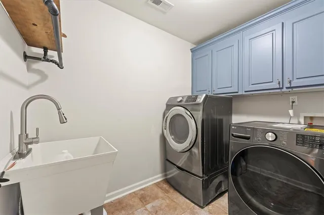 a utility room with sink dryer and washer