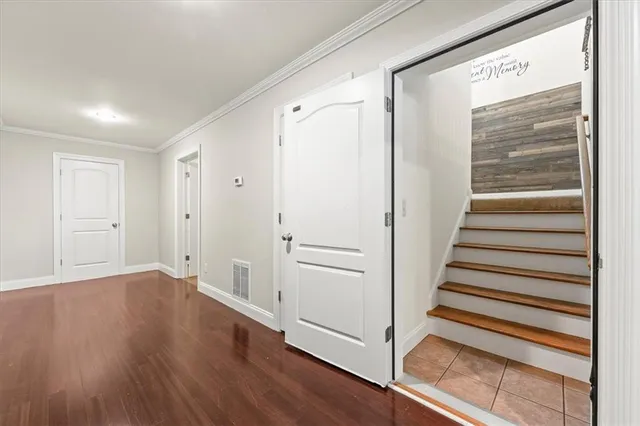 a view of a hallway with wooden floor and entryway