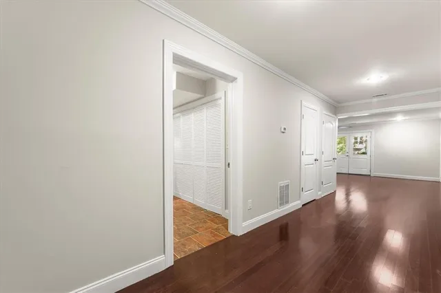a dining room with wooden floor a chandelier fan a wooden table and chairs