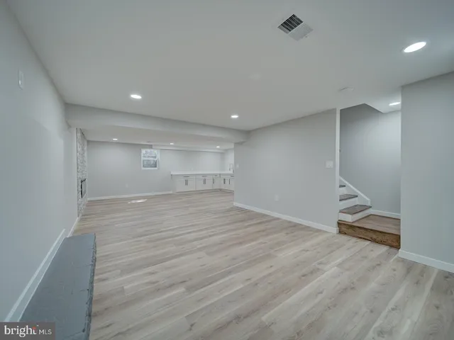 a view of empty room with wooden floor and fireplace