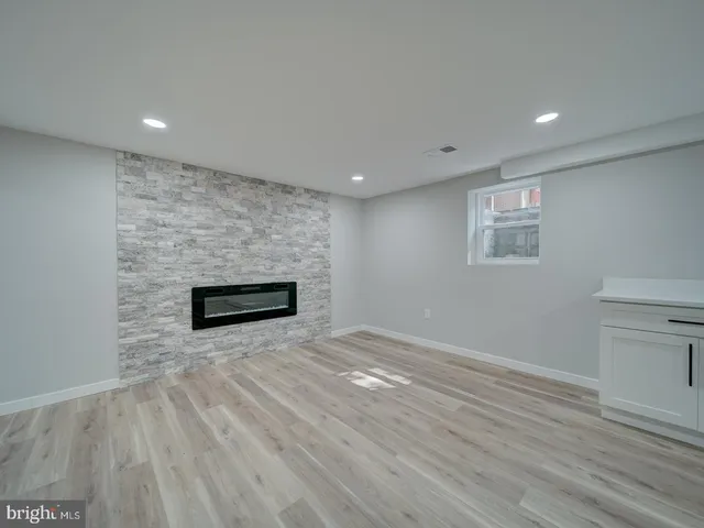 a view of a hallway with wooden floor and a bathroom