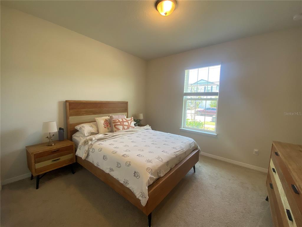 9610 Rally Spring Loop Wesley Chapel, FL 33545 - Photo 13 of 38 a bed sitting in a bedroom next to a window