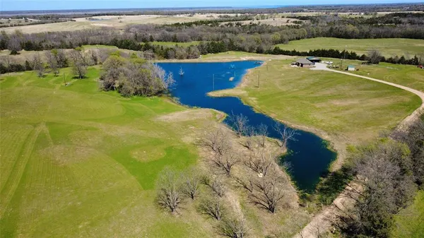 an aerial view of a residential houses with outdoor space and river
