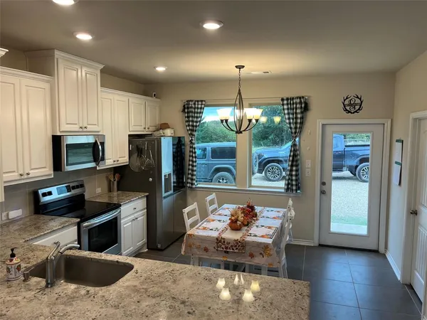 a kitchen with a refrigerator a stove a microwave a sink and cabinets