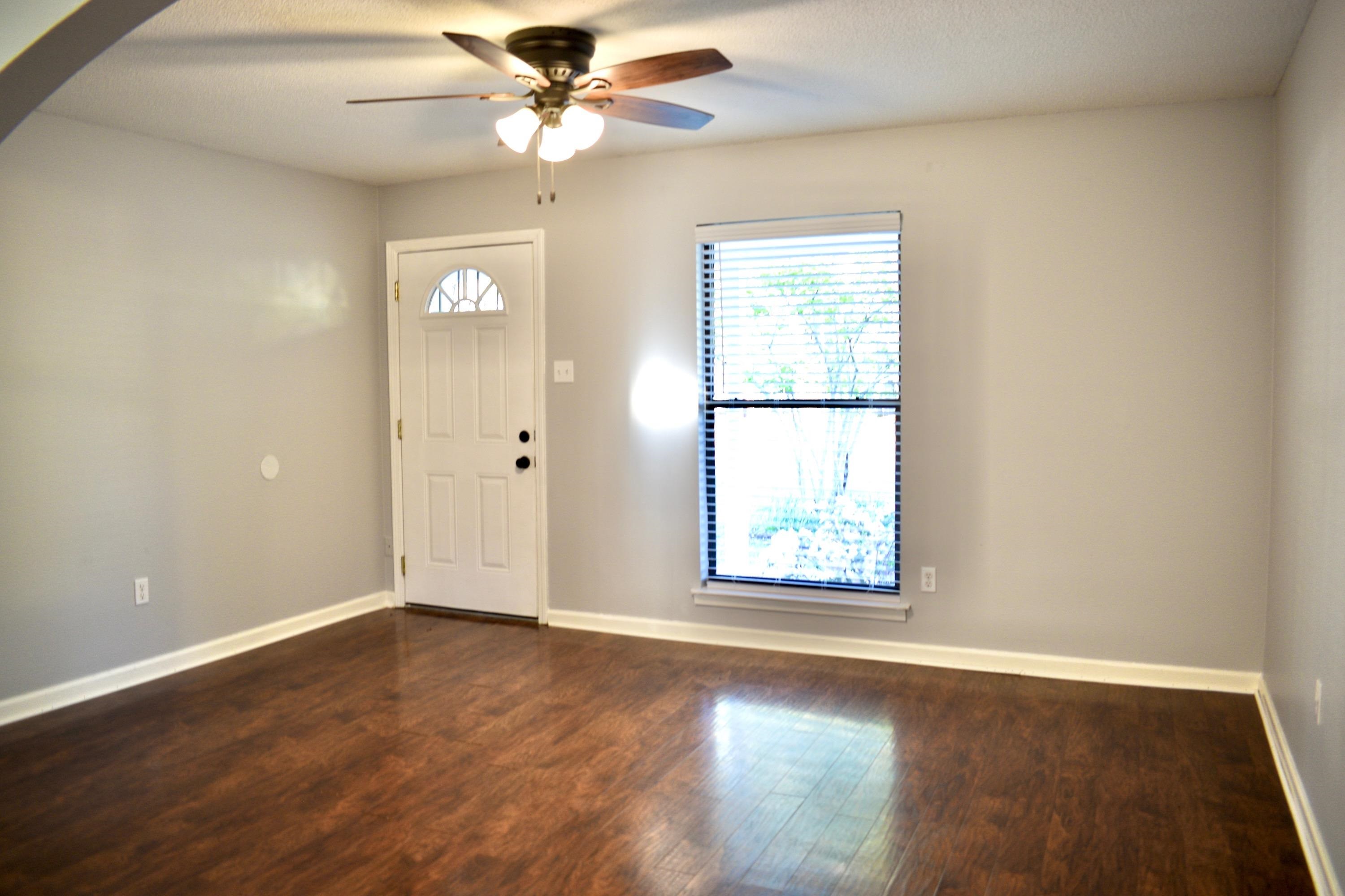925 Greenview Road Collierville, TN 38017 - Photo 8 of 29 an empty room with wooden floor fan and windows