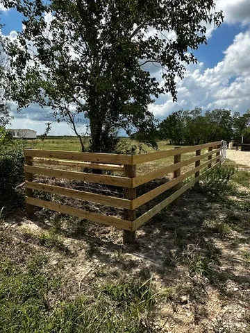 a view of a yard with wooden fence