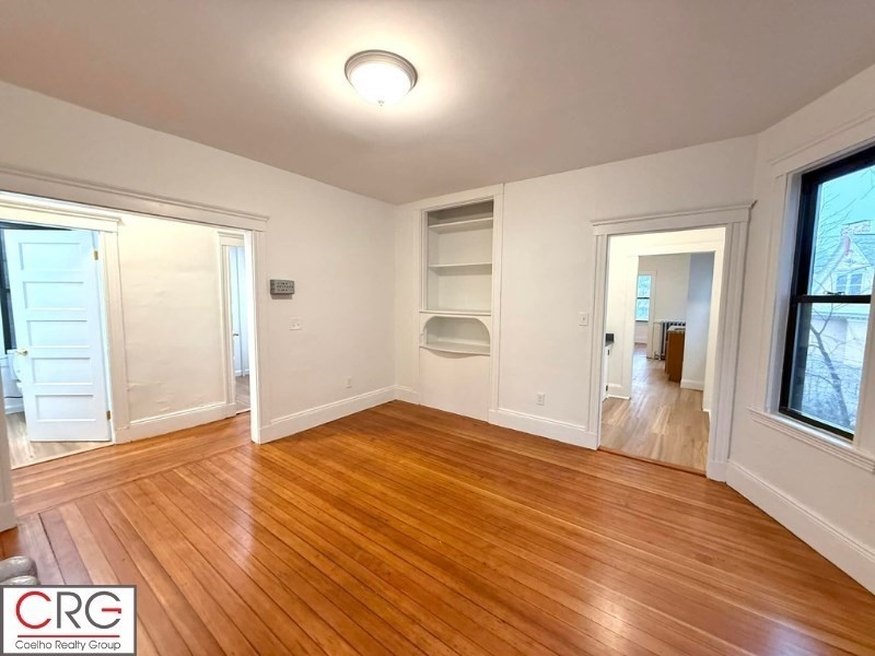 24 University Road, Unit 1 Brookline, MA 02446 - Photo 13 of 38 an empty room with wooden floor and windows