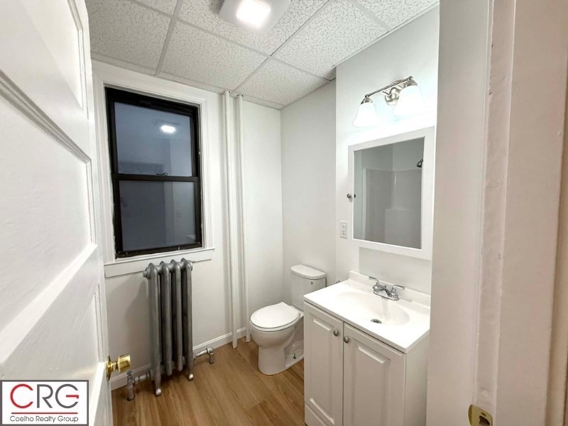 24 University Road, Unit 1 Brookline, MA 02446 - Photo 14 of 38 a bathroom with a toilet sink and mirror