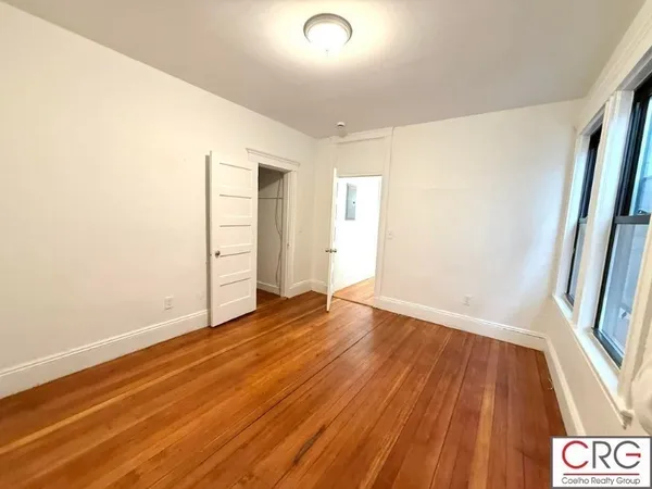 an empty room with wooden floor and door
