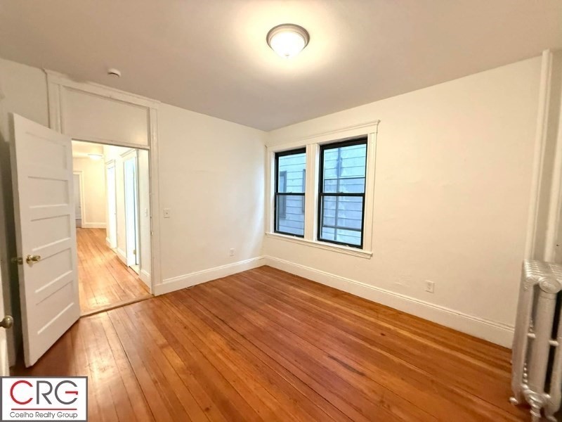 24 University Road, Unit 1 Brookline, MA 02446 - Photo 21 of 38 an empty room with wooden floor and windows