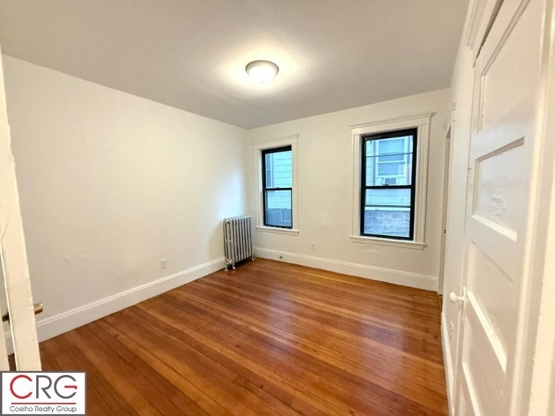 24 University Road, Unit 1 Brookline, MA 02446 - Photo 23 of 38 an empty room with wooden floor and windows