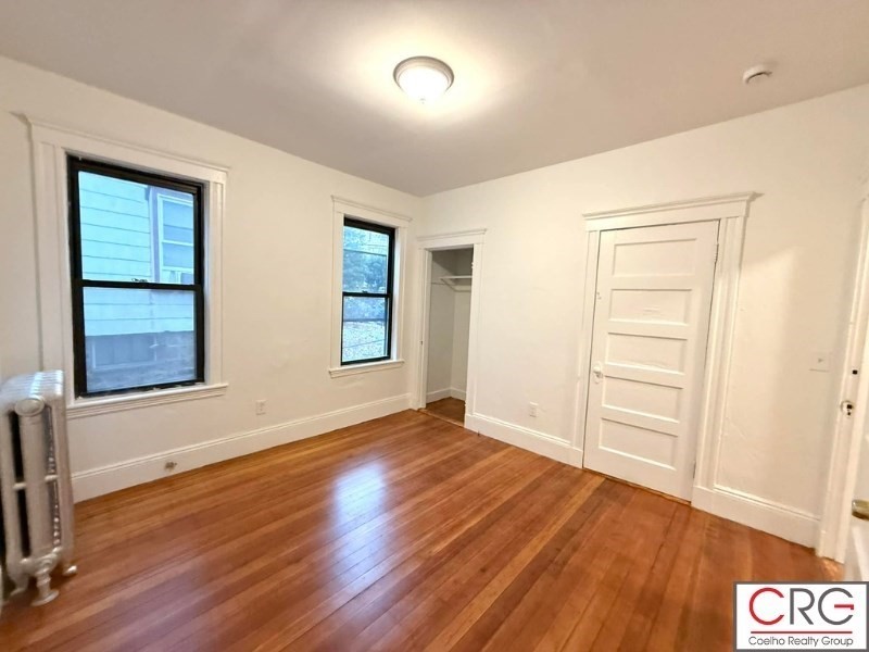 24 University Road, Unit 1 Brookline, MA 02446 - Photo 24 of 38 an empty room with wooden floor and windows