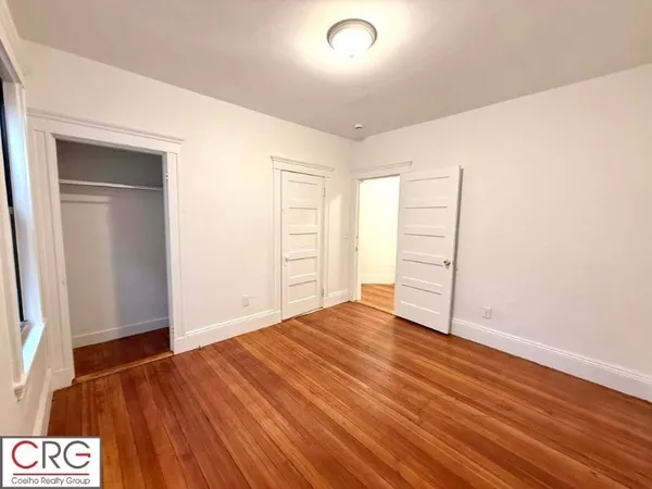 an empty room with wooden floor and closet