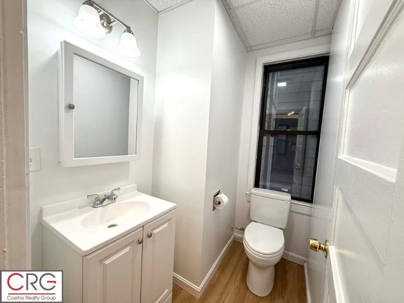24 University Road, Unit 1 Brookline, MA 02446 - Photo 27 of 38 a bathroom with a toilet sink and mirror