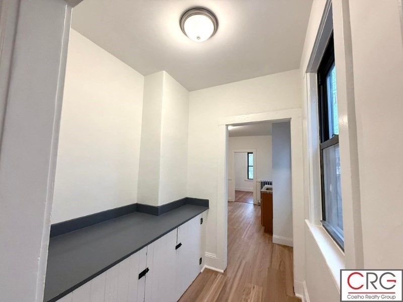 24 University Road, Unit 1 Brookline, MA 02446 - Photo 3 of 38 a view of hallway with wooden floor