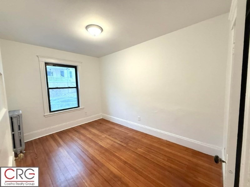 24 University Road, Unit 1 Brookline, MA 02446 - Photo 33 of 38 an empty room with wooden floor and windows