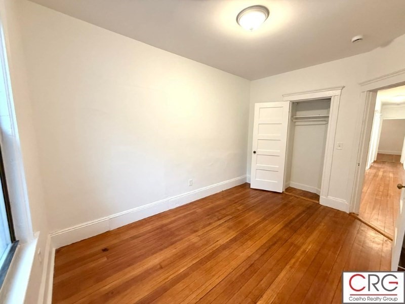 24 University Road, Unit 1 Brookline, MA 02446 - Photo 34 of 38 a view of an empty room and wooden floor