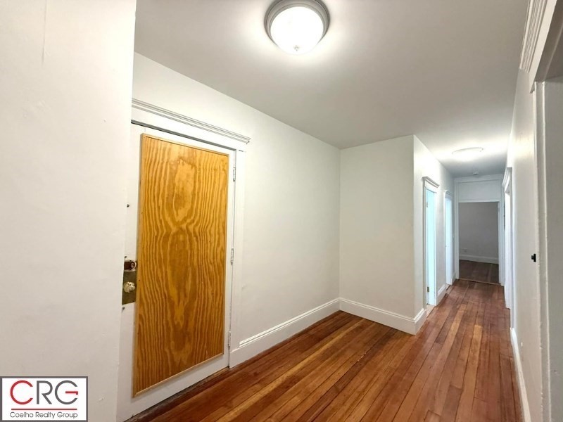 24 University Road, Unit 1 Brookline, MA 02446 - Photo 37 of 38 a view of a hallway with wooden floor