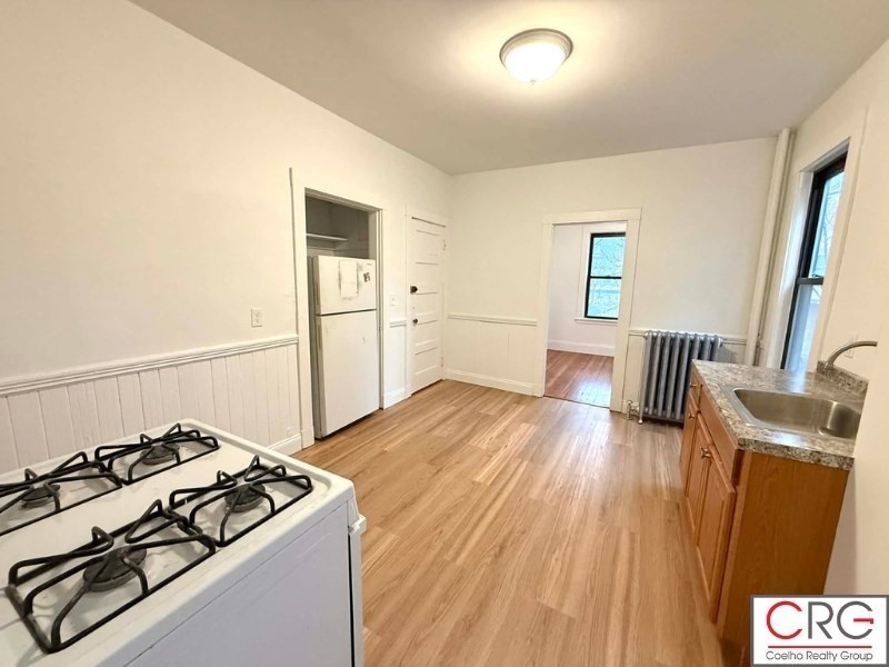 24 University Road, Unit 1 Brookline, MA 02446 - Photo 4 of 38 a kitchen with granite countertop a stove and a refrigerator