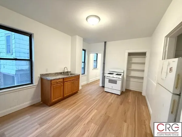 a kitchen with granite countertop a refrigerator and a stove top oven