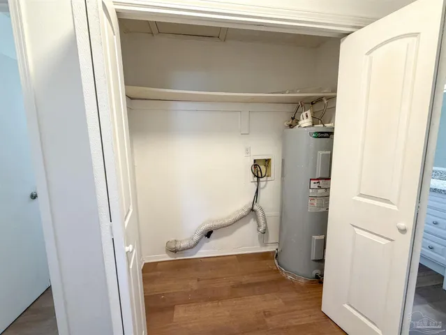 an empty room with wooden floor chandelier fan and windows