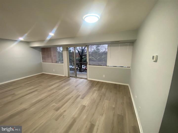 5801 Quantrell Avenue, Unit L9 Alexandria, VA 22312 - Photo 2 of 11 an empty room with wooden floor and windows