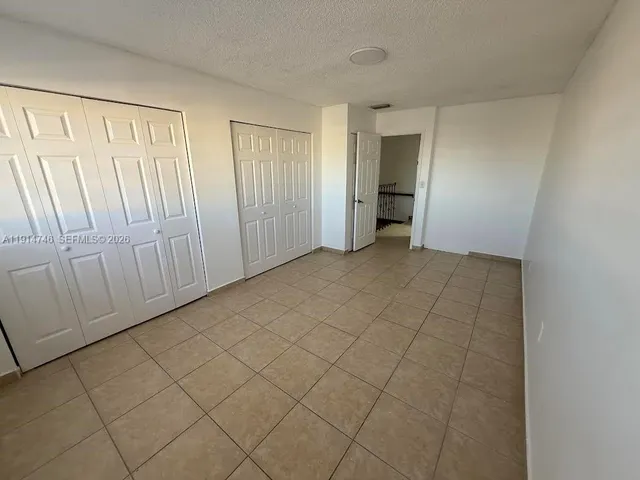 a bathroom with a granite countertop toilet sink and mirror