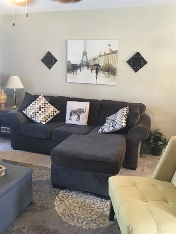 a living room with furniture and painting on the wall