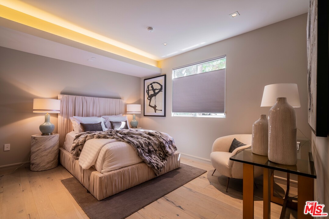 2391 Roscomare Road, Unit 103 Los Angeles, CA 90077 - Photo 15 of 32 a bedroom with a bed and wooden floor