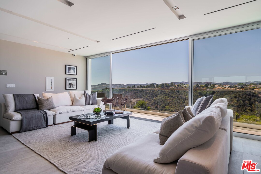 2391 Roscomare Road, Unit 103 Los Angeles, CA 90077 - Photo 21 of 32 a living room with furniture and a large window