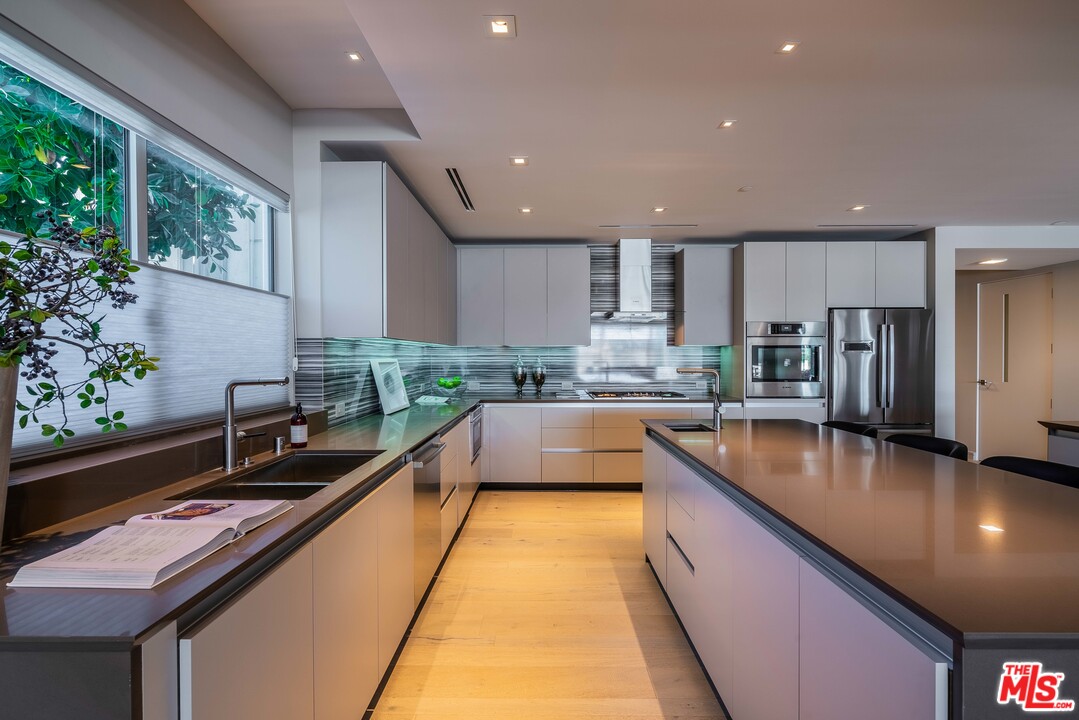 2391 Roscomare Road, Unit 103 Los Angeles, CA 90077 - Photo 5 of 32 a large kitchen with stainless steel appliances kitchen island granite countertop a sink and cabinets
