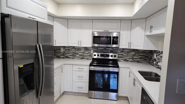 a kitchen with stainless steel appliances a stove a sink and a refrigerator