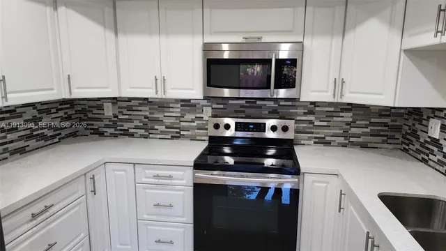 a kitchen with stainless steel appliances a stove a microwave and cabinets