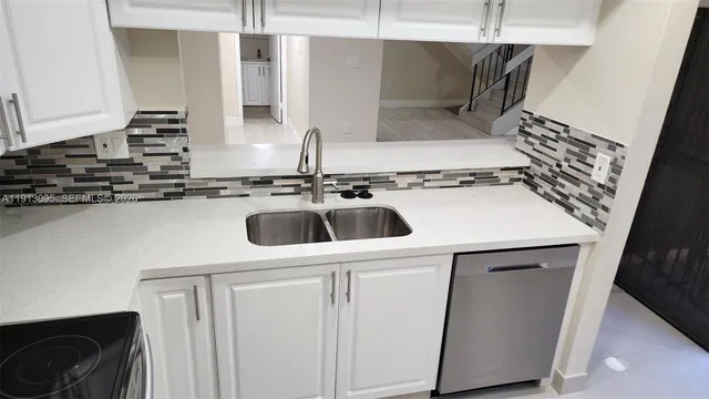a kitchen with a sink a stove and cabinets