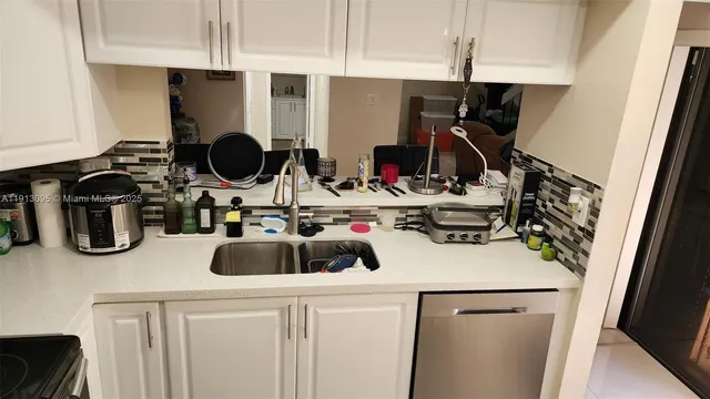 a kitchen with a sink a stove and cabinets