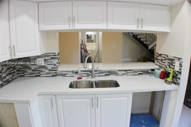5975 Southwest 137th Avenue, Unit 803 Miami, FL 33183 - Photo 16 of 31 a kitchen with a sink a stove and cabinets