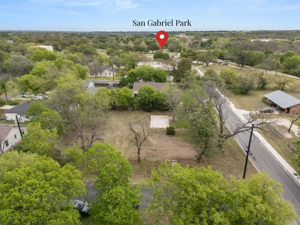 an aerial view of residential houses with outdoor space and trees