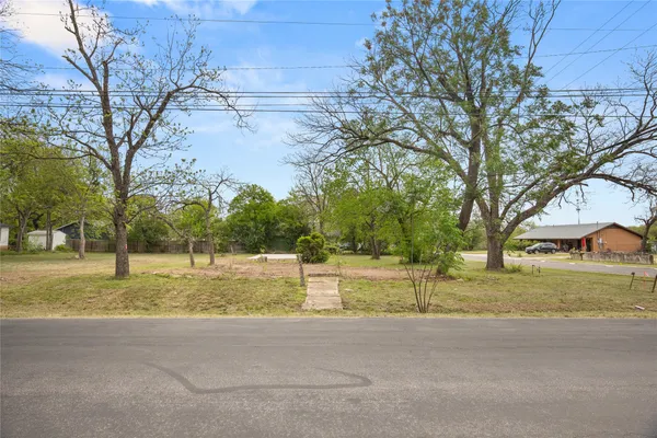 a view of a yard with a house and large trees