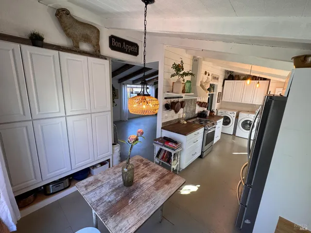 a view of a hallway with wooden floor and a bathroom