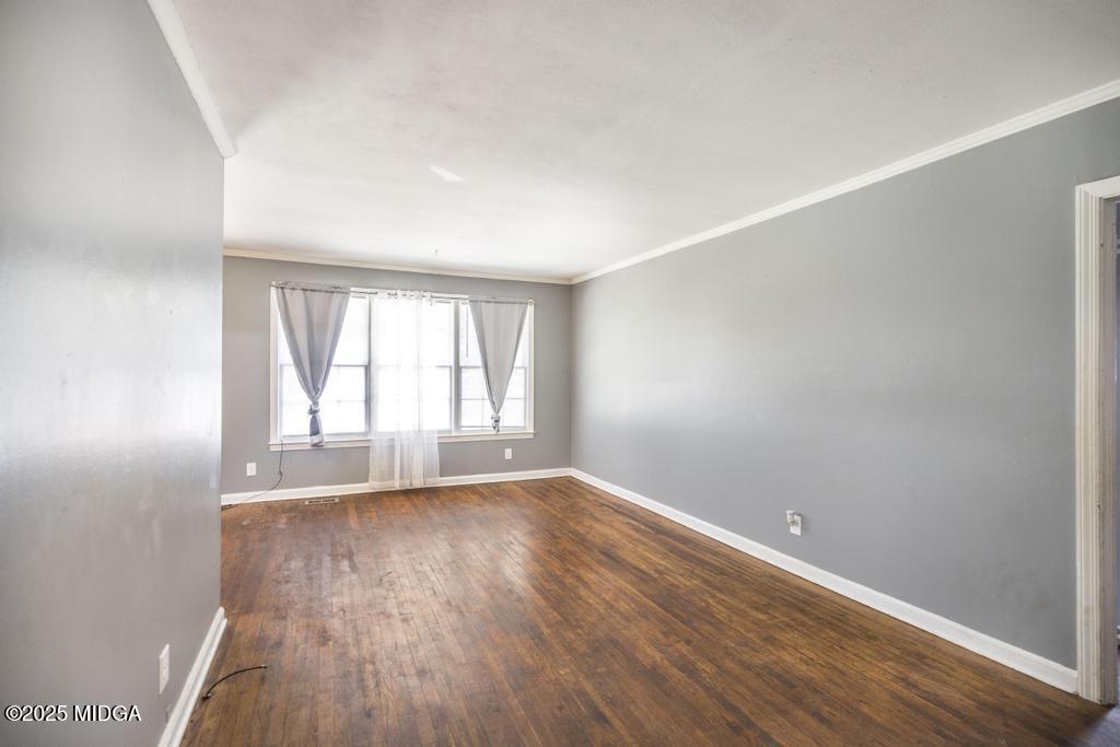 1940 Manson Road Macon, GA 31217 - Photo 8 of 28 a view of an empty room with wooden floor and a window
