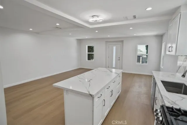 a view of kitchen with granite countertop cabinets and wooden floor