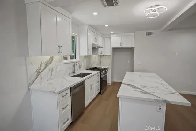 a kitchen that has a sink and a stove in it