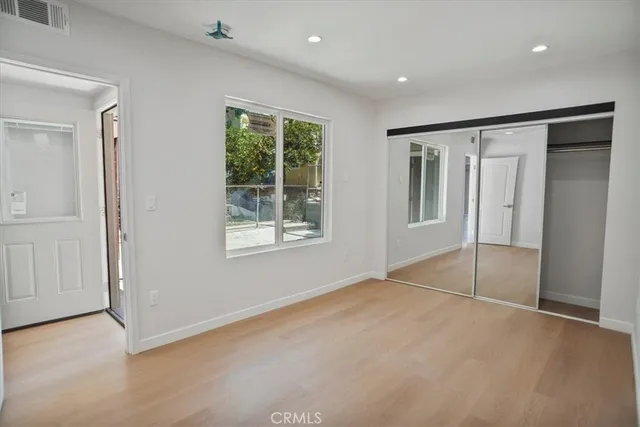 an empty room with windows and closet