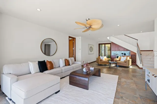 a living room with furniture kitchen view and a window