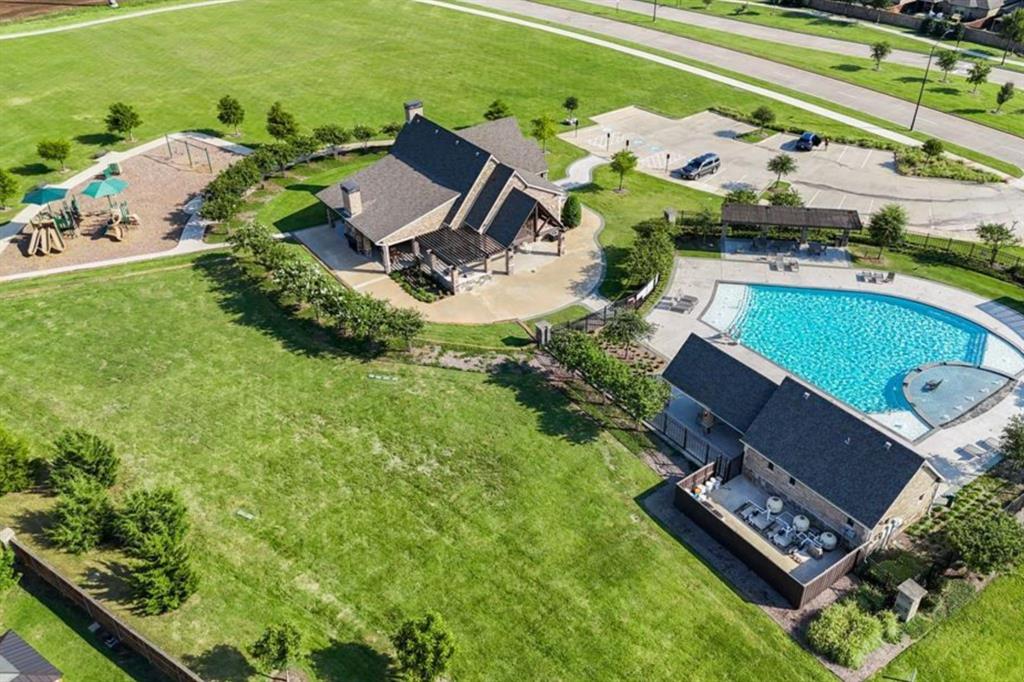 11732 Wulstone Road Fort Worth, TX 76052 - Photo 28 of 34 Community recreation center featuring a swimming pool with integrated water features, a shaded patio area, a playground with multiple structures, and a dedicated parking area