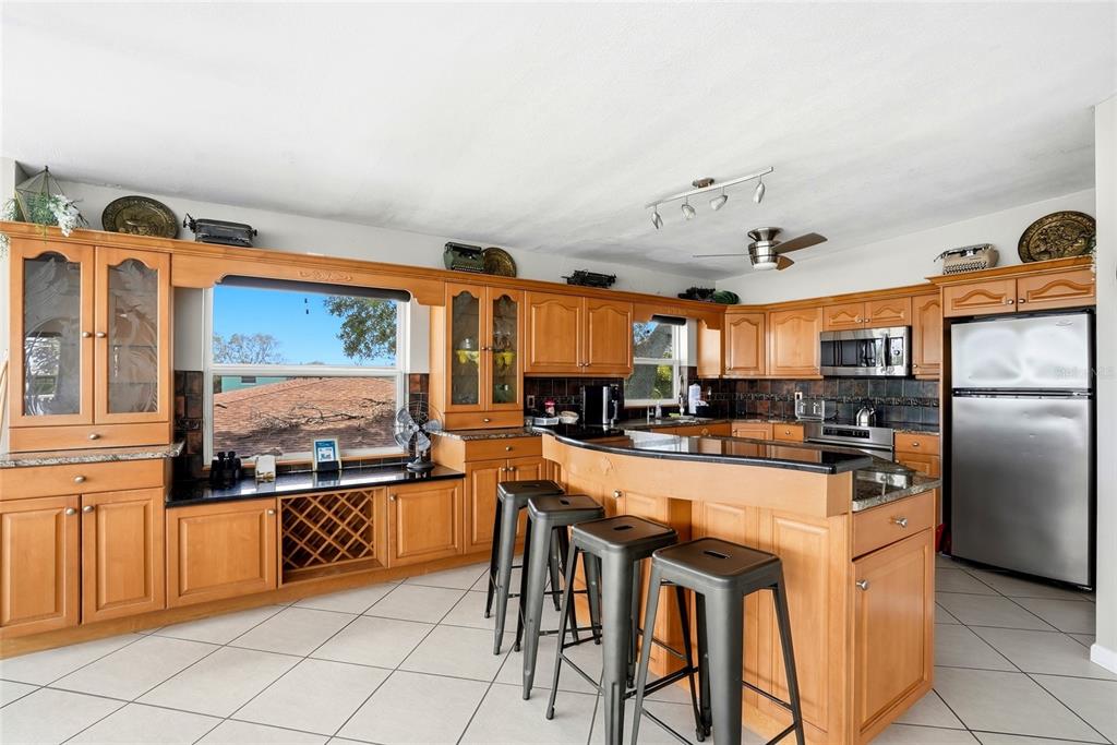 2311 Bay Boulevard Indian Rocks Beach, FL 33785 - Photo 9 of 80 a kitchen with stainless steel appliances granite countertop a stove and a refrigerator